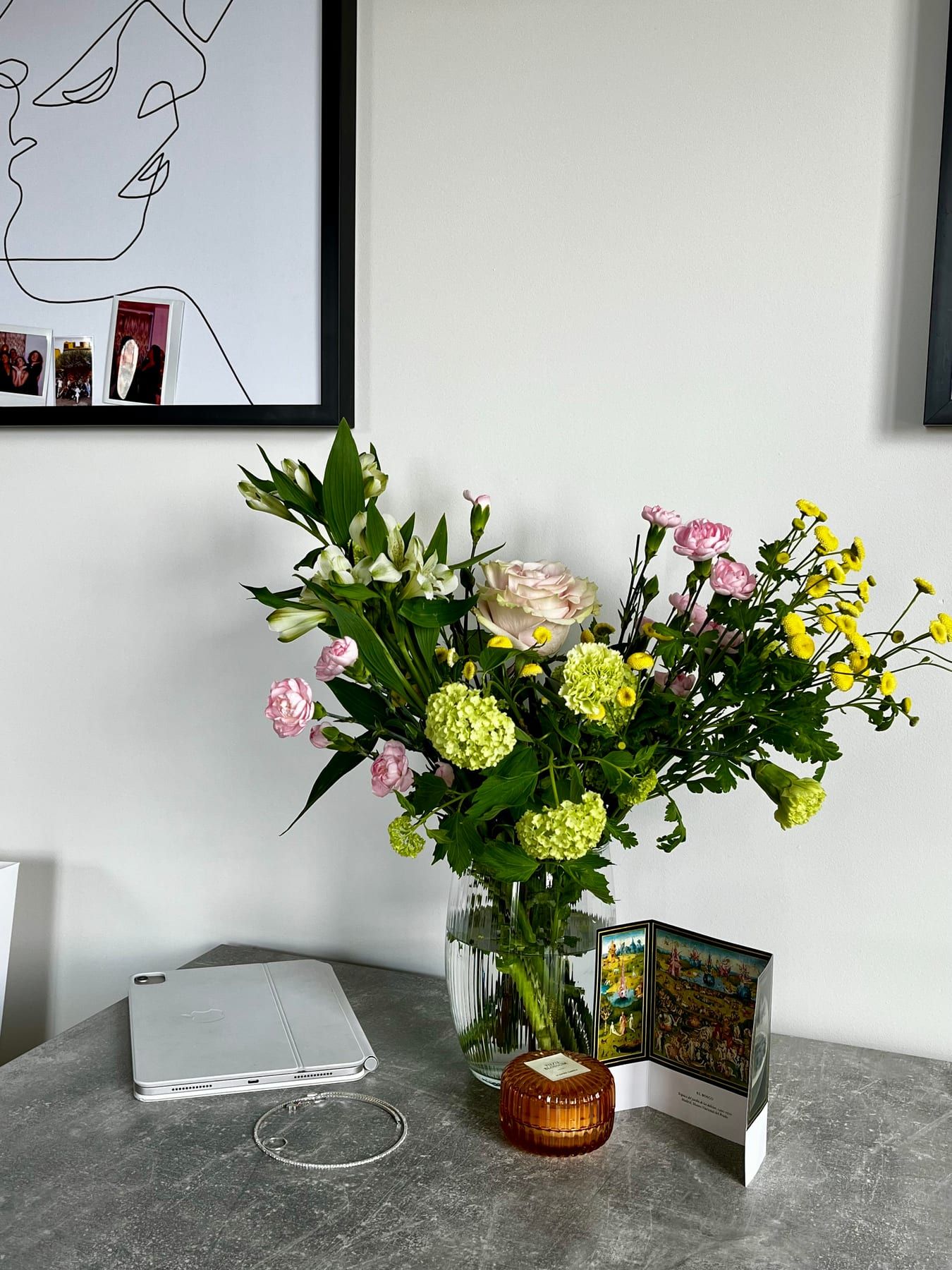 Mixed bouquet in a ribbed glass vase on a desk